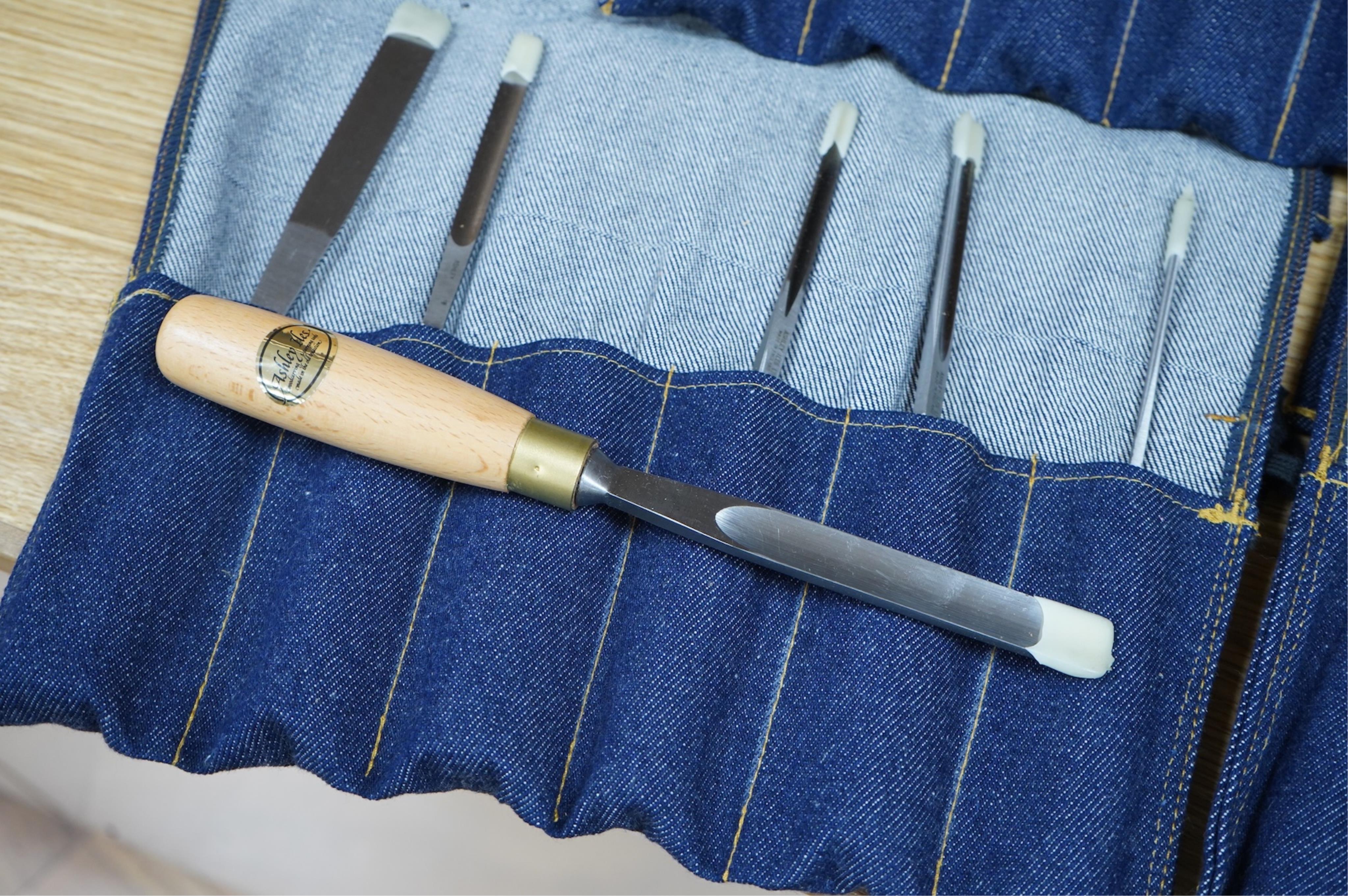 Three sets of Ashley Iles wood carving tools, contained within denim tool rolls; the York Set, the Supplementary Set No.Two, and the Supplementary Set No.Three, each comprising of six chisels (18 chisels in total)